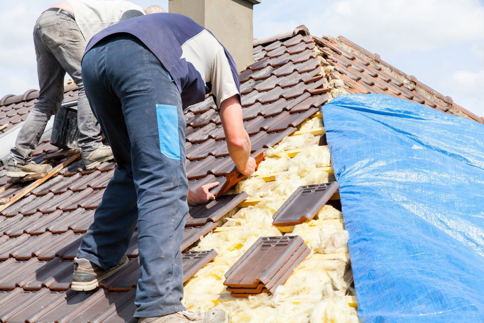 deux hommes travaillent sur le toit d' une maison .